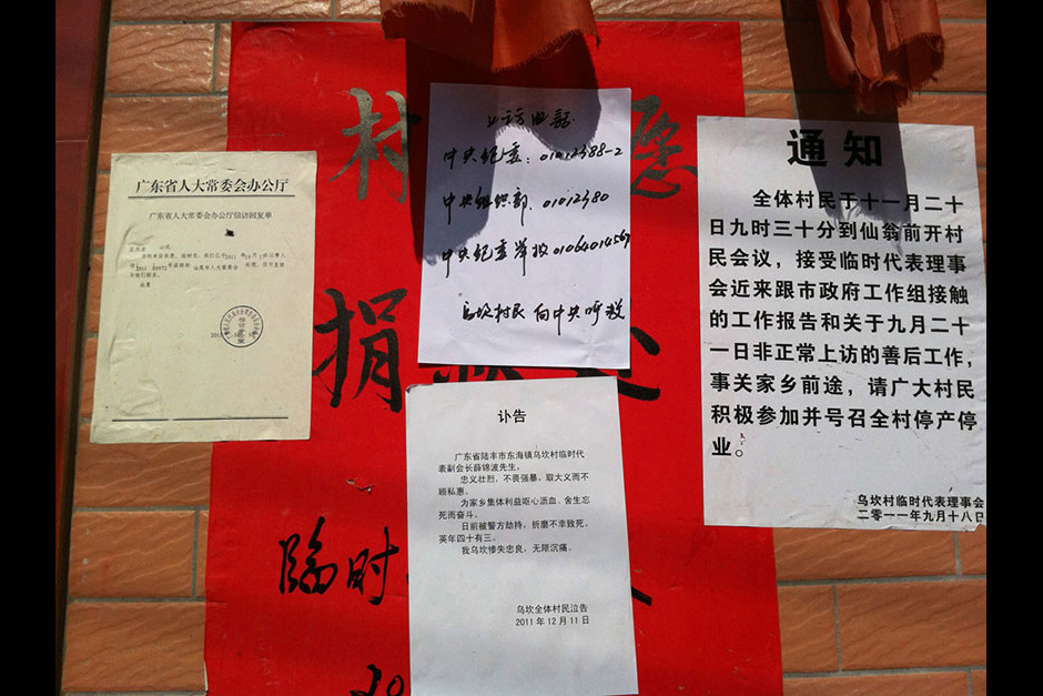 Postings outside the Village Party Committee house include phone numbers to contact and petition the government, Xue Jinbo’s obituary, and a call for a general strike. The poster in the background is asking for donations to support the villagers.
